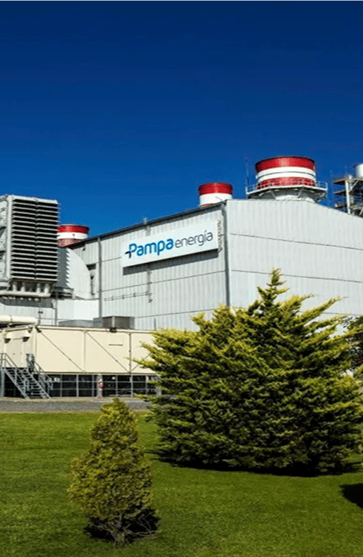 Pampa Energía power plant building with the company logo and red-and-white exhaust stacks